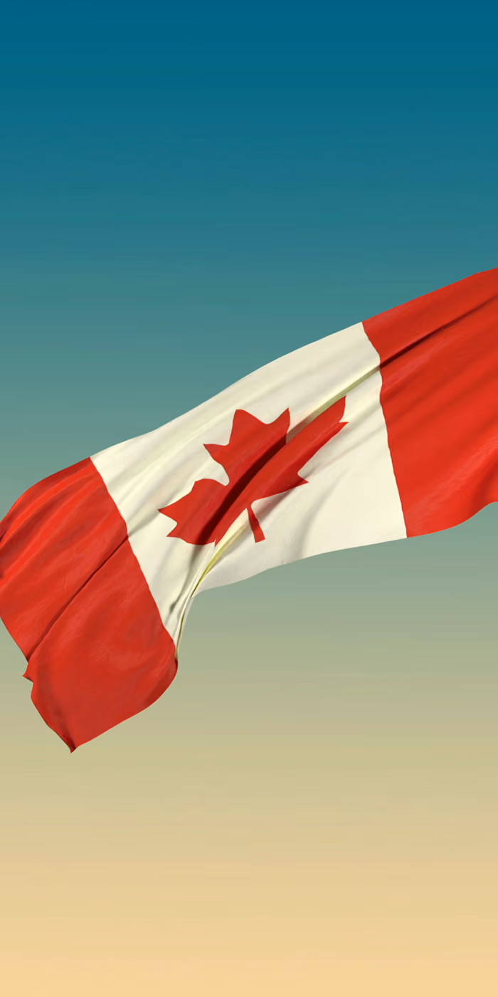 The Canadian flag waves against the sky.