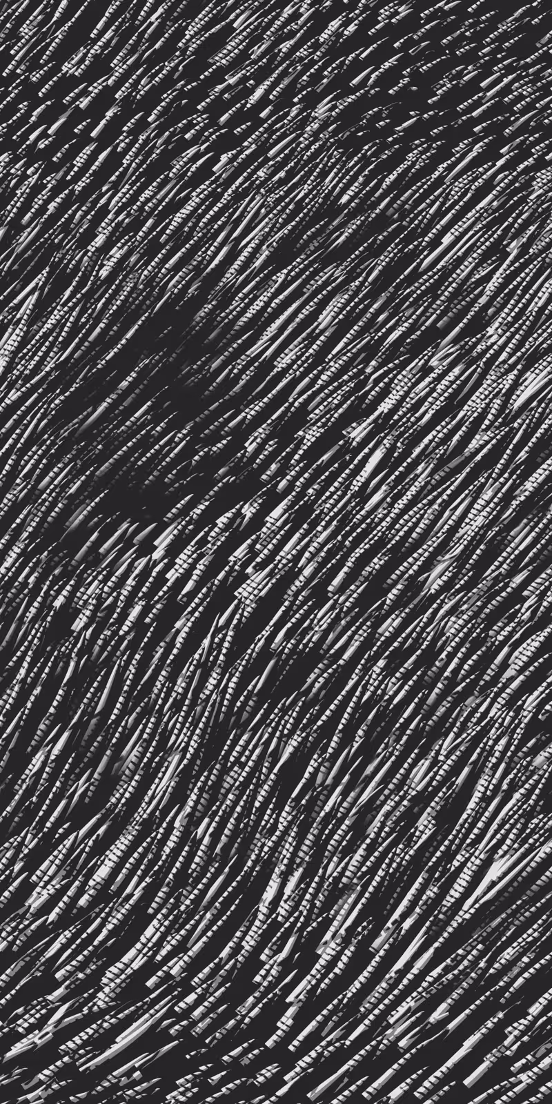 Wind sweeps through a field of grass in black and white.
