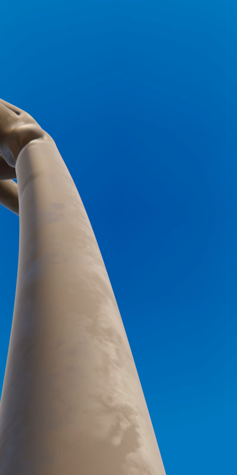 An inflatable black skydancer sways against a bright blue sky.