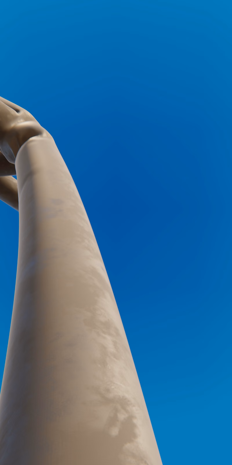 An inflatable black skydancer sways against a bright blue sky.
