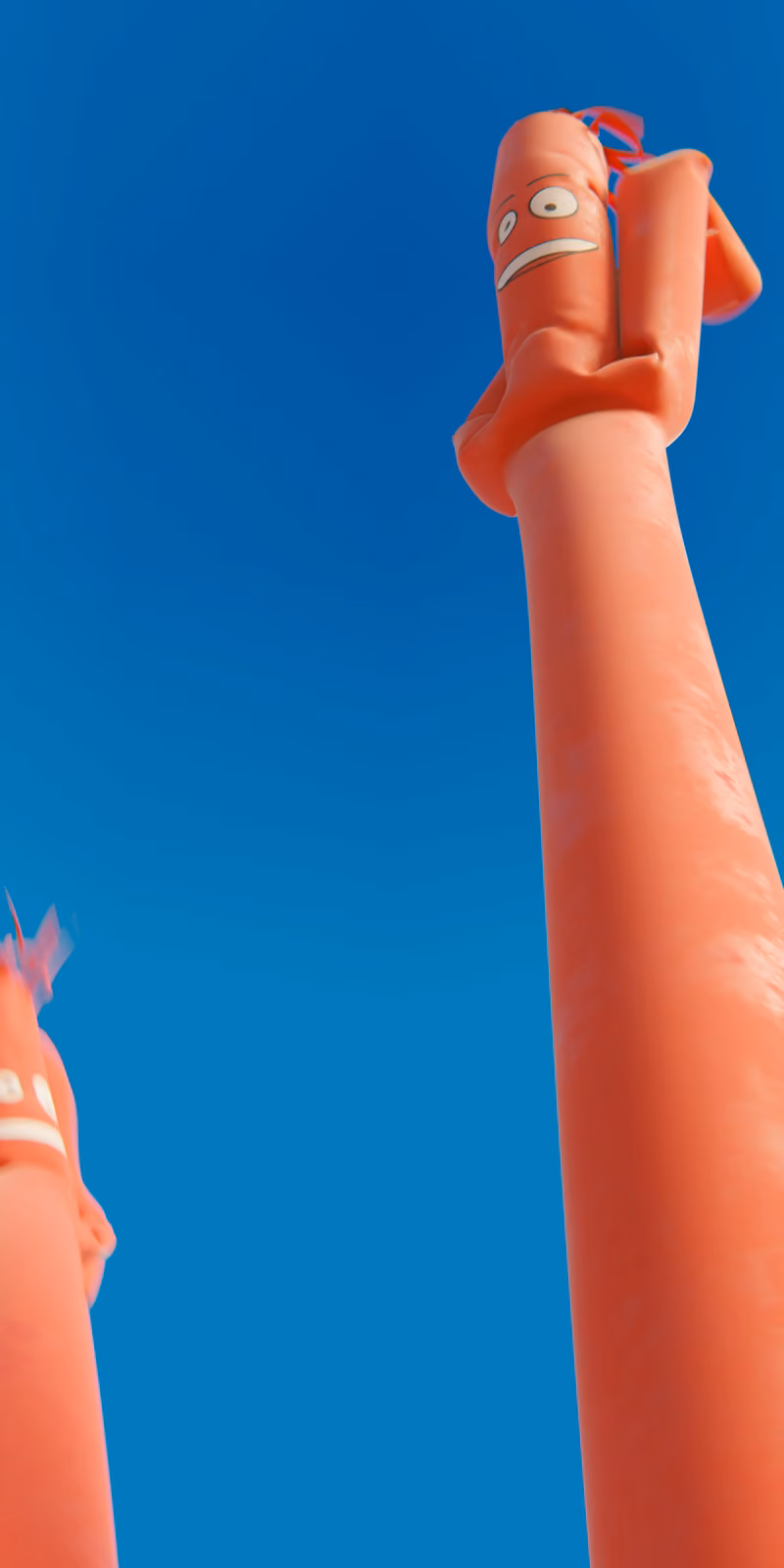 Two inflatable red skydancers sway against a bright blue sky.