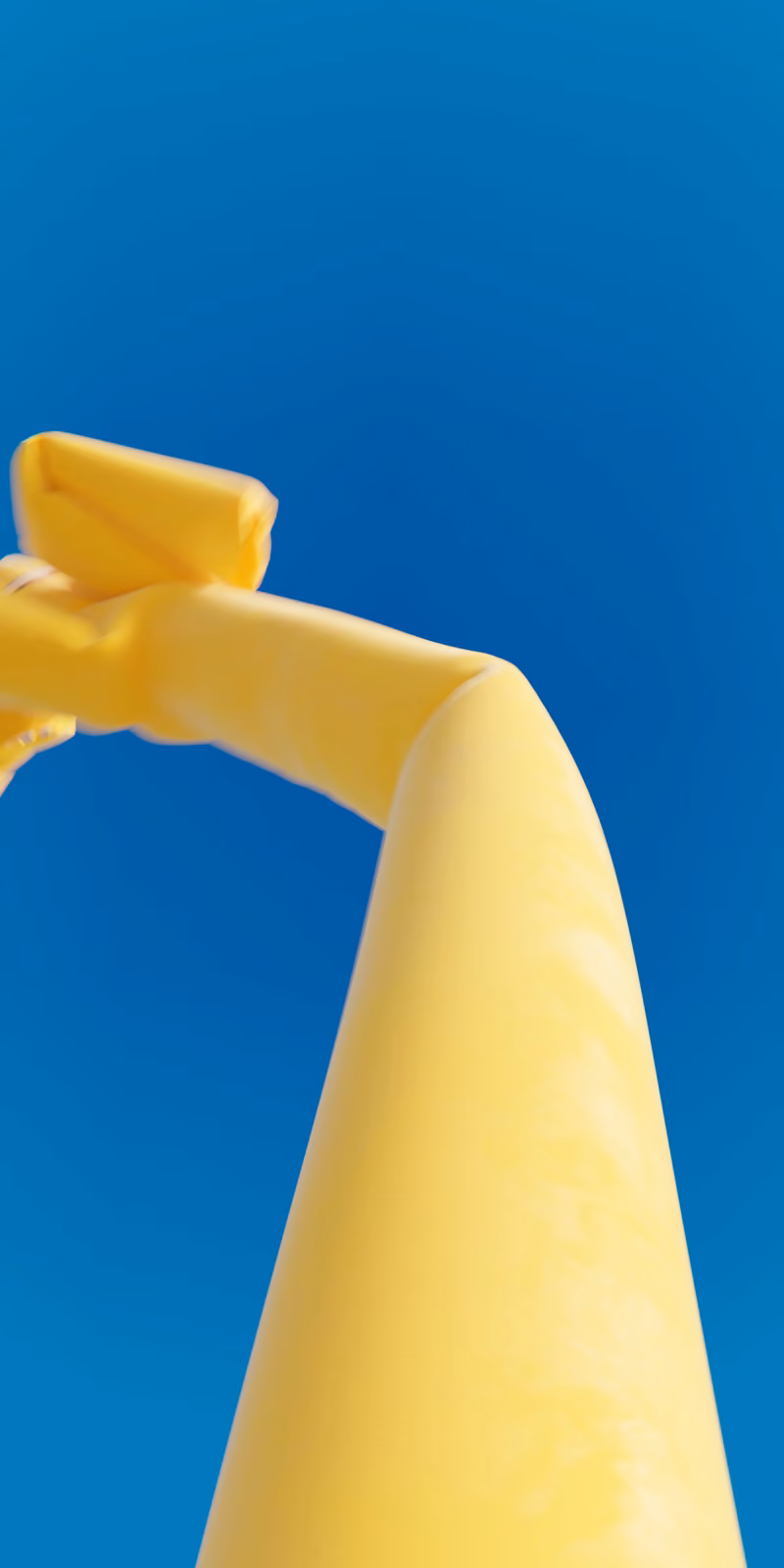 An inflatable yellow skydancer sways against a bright blue sky.